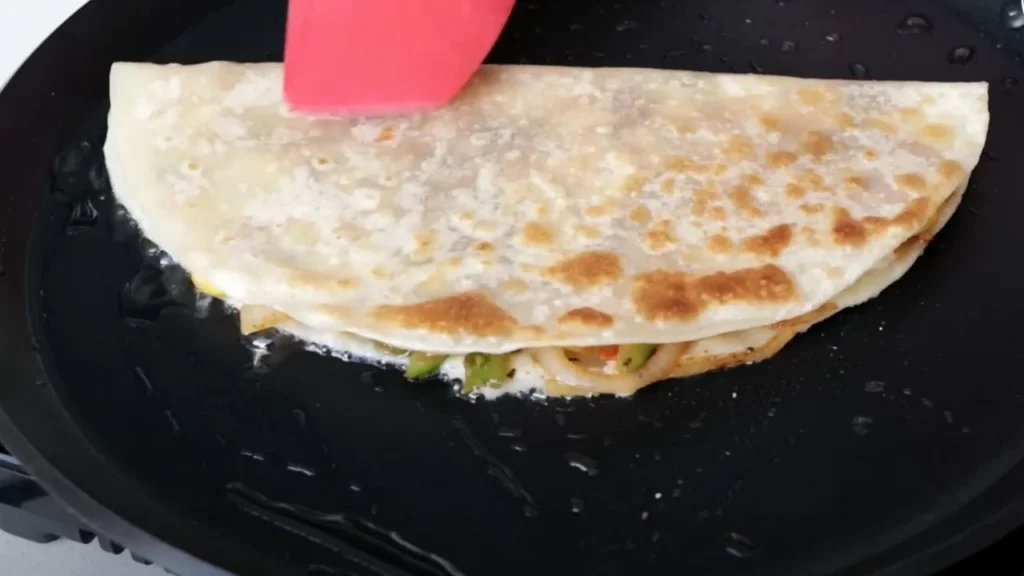 a quesadilla being cooked on a pan, veg quesadilla recipe